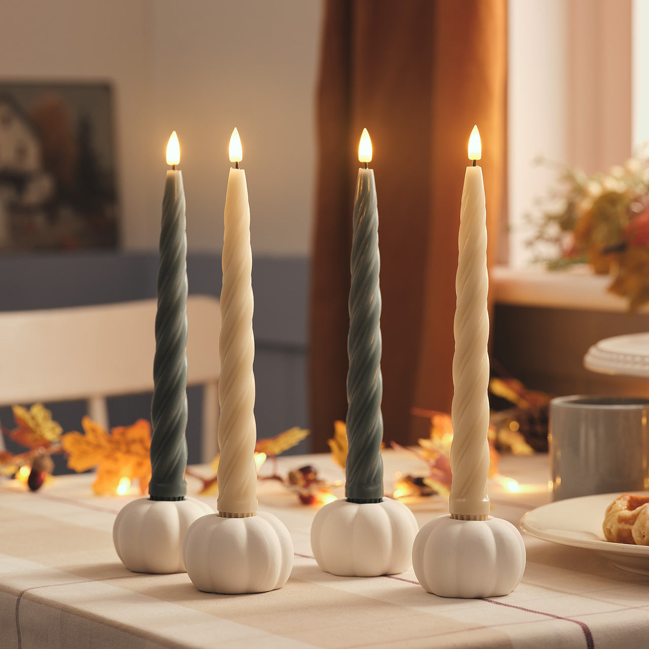 4er Set TruGlow® gedrehte Echtwachs-LED‑Stabkerzen mit 2 Keramik-Kürbis-Kerzenhaltern & Fernbedienung beleuchtet auf Herbsttisch dekoriert