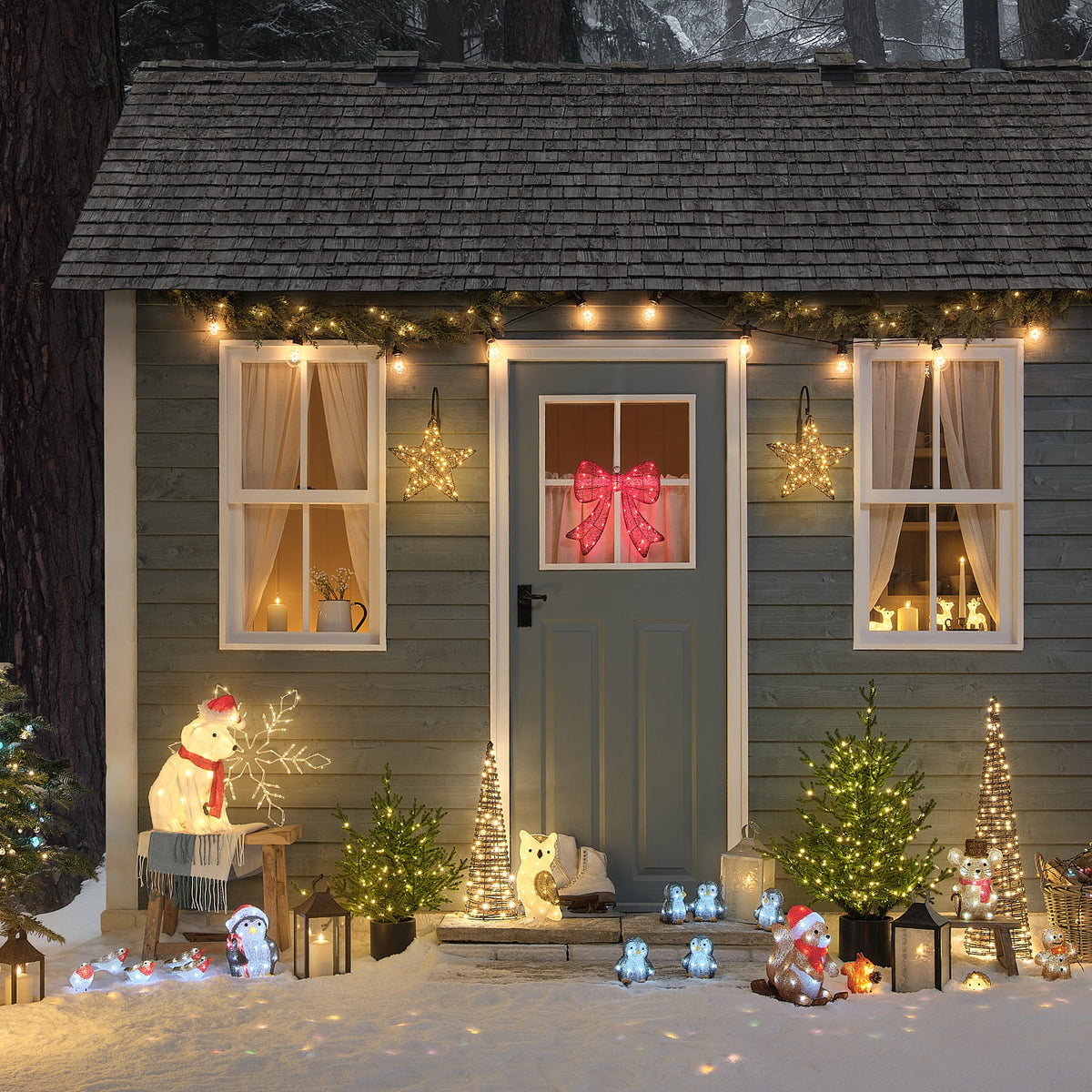 Festliche Weihnachtsszene mit verschiedenen cremefarbenen und weißen Plüsch-Tierfiguren mit roten Weihnachtsmützen, illuminiertem Weihnachtshaus mit warmweißer LED-Beleuchtung, roten Weihnachtsdekoelementen und grünen Grünflächen-Akzenten – umfassendes Außen-Weihnachtsdisplay mit charmanten Tierfiguren für gehobene Garten- und Hausdekorationen.