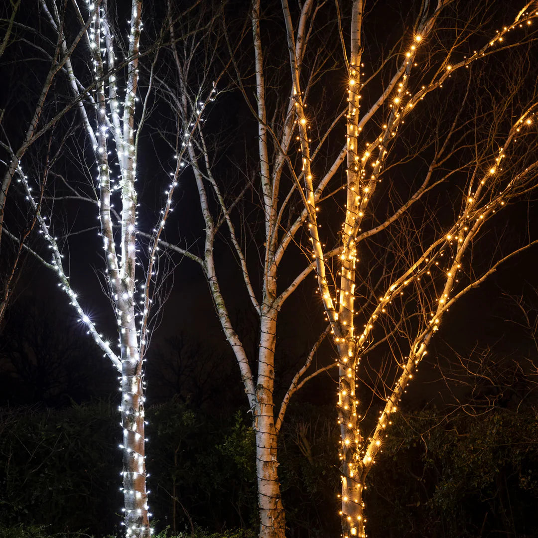 Zwei Bäume mit warmweißer und kaltweißer LED-Lichterkette im Vergleich